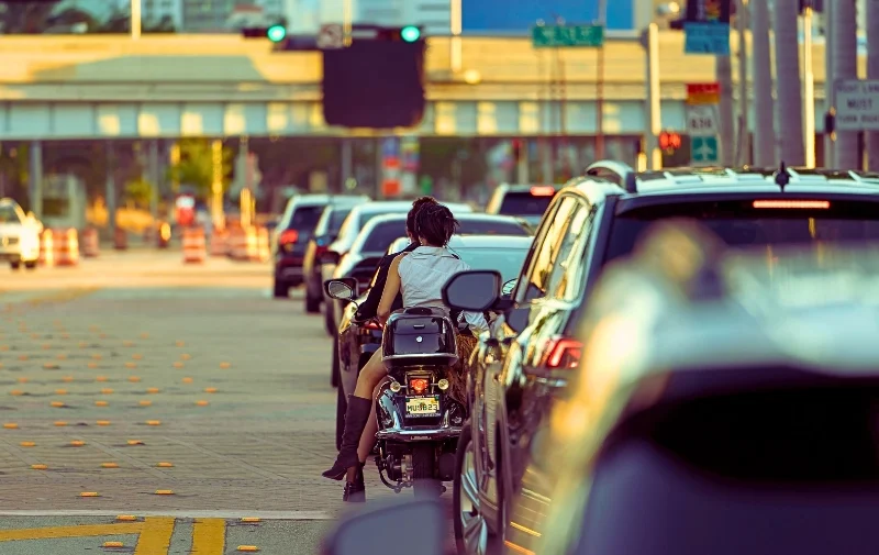 Chicago Ranks Third for Worst Traffic Conditions in the US 1 Two people on a motorcycle wait in city traffic.