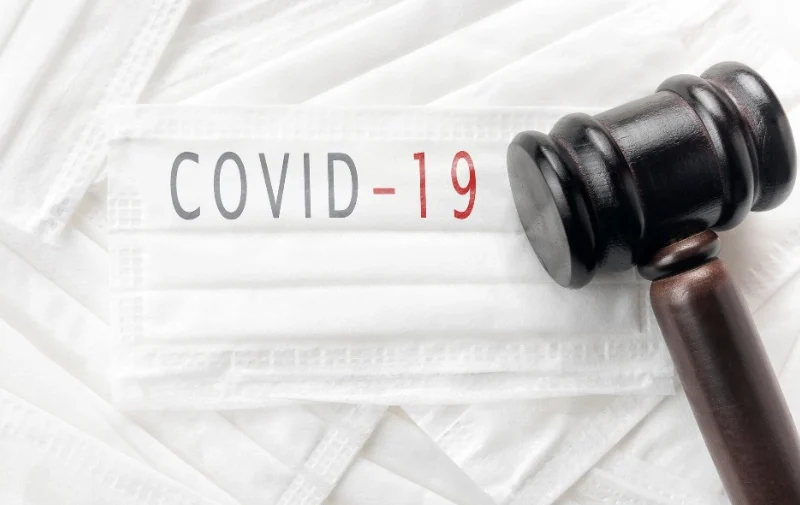 Covid-19 Victims Are Filing These Types of Lawsuits 1 A wooden judge's gavel resting on white medical masks.