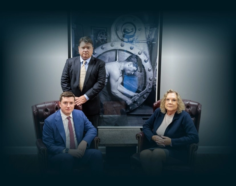 Chicago lawyers, John Serkland, Donna Zadeikis and Alexander Pino pose in front of a large industrial photograph.
