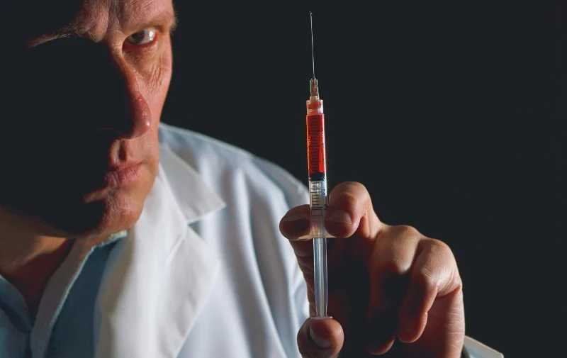 Vampire Treatments: The Dangers of Young Blood Injections 1 A man in a lab coat holding a syringe.