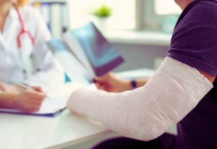 Patient with arm cast reviews X-rays with doctor.