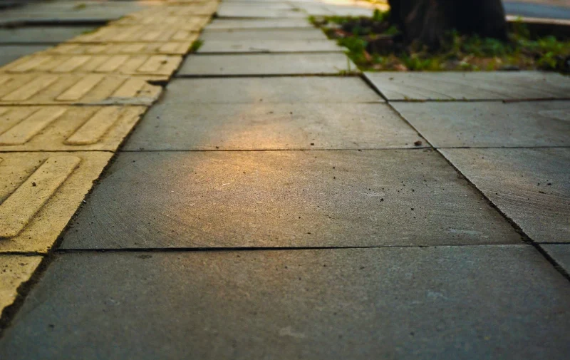 Close-up of gray stone tiles on a city sidewalk.