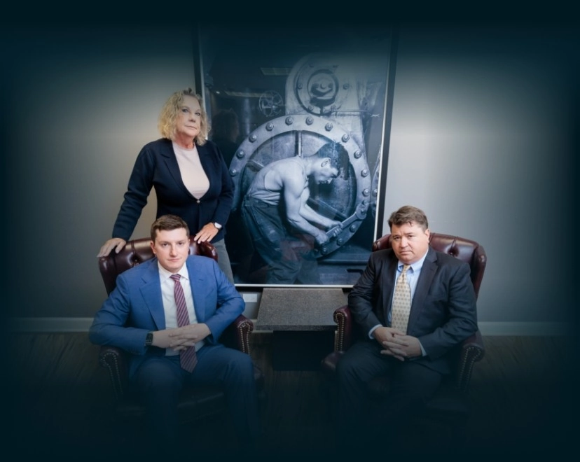 Chicago lawyers, John Serkland, Donna Zadeikis and Alexander Pino pose in front of a large industrial photograph.