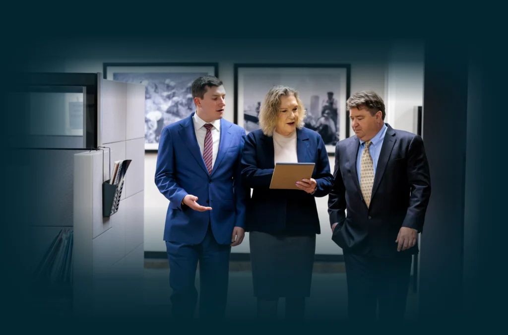 Chicago lawyers, John Serkland, Donna Zadeikis and Alexander Pino discussing information shown on a tablet.