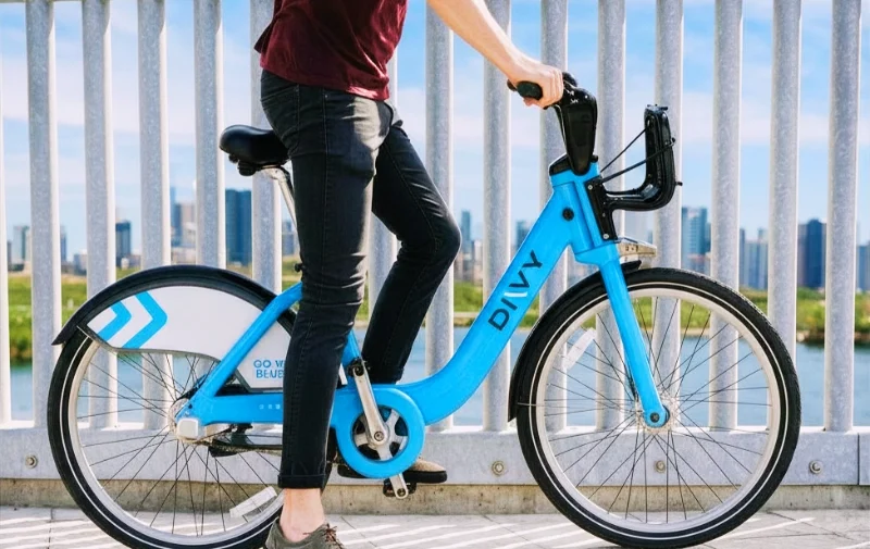 Person riding a blue Divvy bicycle in front of railing. injured while riding a Divvy bike