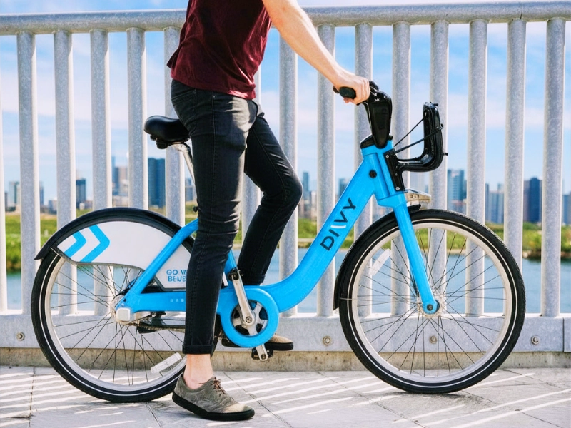 Person riding a blue Divvy bicycle in front of railing. injured while riding a Divvy bike